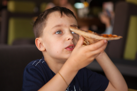 Child having fun eating pizzaの写真素材