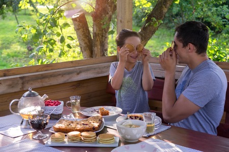 Family Breakfast in a country house. Father and son pretending faces with pancakesの写真素材