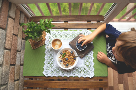 Breakfast with oatmeal, granola and blueberry on wooden background