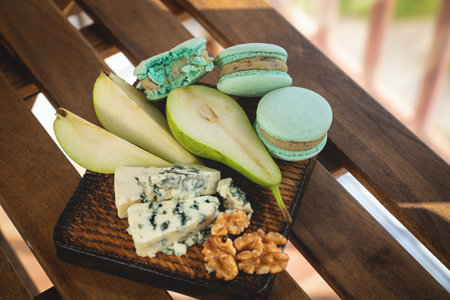 Macaroons, Crushed Walnuts And Dried Apricots On A Wooden Surface