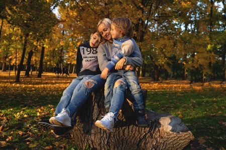Smiling young family into leaves on an autumns dayの写真素材