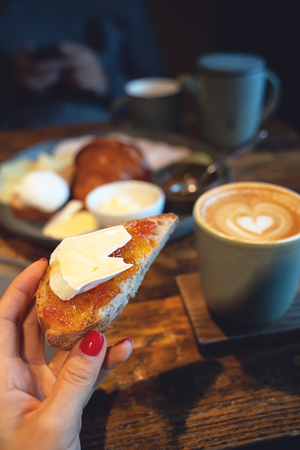 Top view on breakfast with cup of coffee and toast with cheese served on wooden tableの写真素材