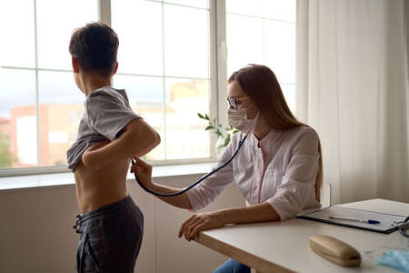 Cute boy with pleasure visiting pediatrician, scheduled check up of babys health, appointment with the family doctor, healthy lifestyleの写真素材