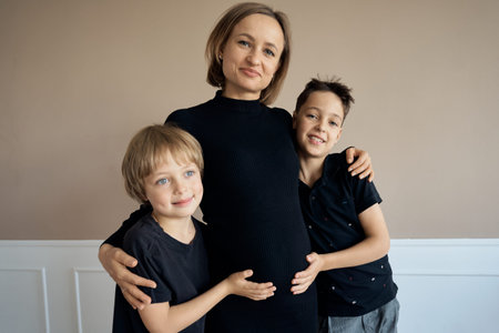 Beautiful pregnant woman with her sons. High quality photoの写真素材