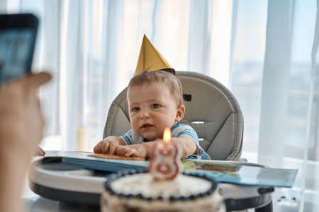 Happy family celebrating a birthday at home in the kitchenの写真素材