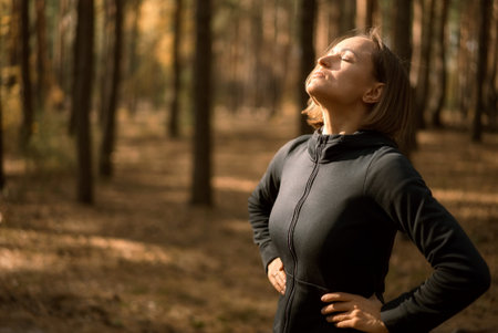 A young woman make yoga position at sunrise. in the autumn forest