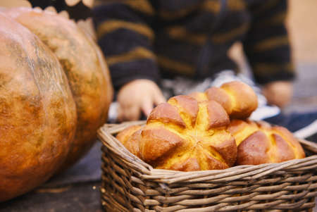 10 Month old baby sit with pumpkin and bun on wooden table in autumn forest . Helloween holiday concept.の写真素材