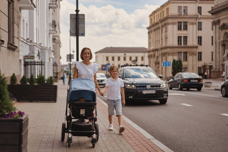 Mother and two kids walking in city center.