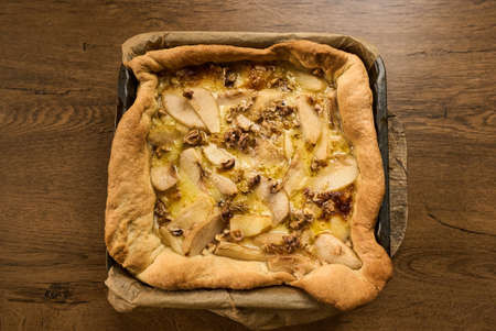 Tart with pear and nuts top view on wooden backgroundの写真素材