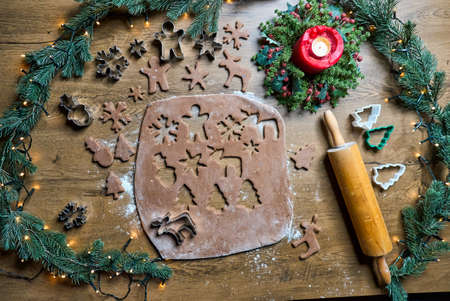 Shortbread dough for gingerbread cookies rolled on the wooden board. Cutting out star shaped cookiesの写真素材