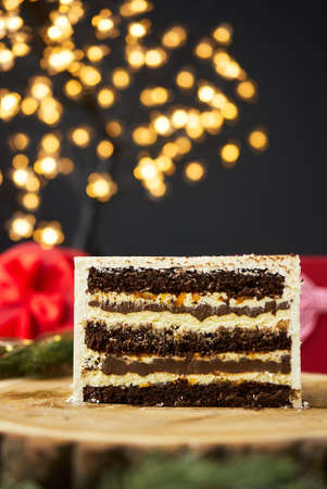 A slice of a cake on a background of christmas lights.の写真素材