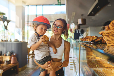 young family mom and son eat tasty bean in a cafeの写真素材