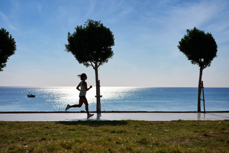 Woman jogging near beach 4k. Caucasian woman jogging in the morning near the beach in Turkeyの写真素材