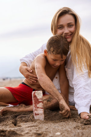 Mom hugs her 6 year old son on the beach.の写真素材