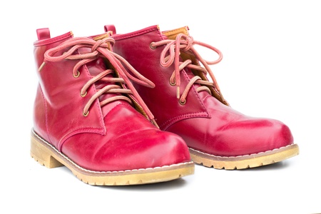 Red boots and untied shoelaces on the white background.の写真素材
