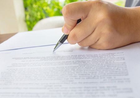 close up of female business hand signing document.