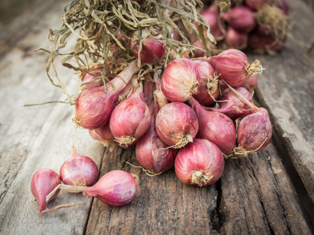 Shallot onions in a group on old wood.
