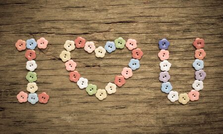 I love you written with flower button on wood.の写真素材
