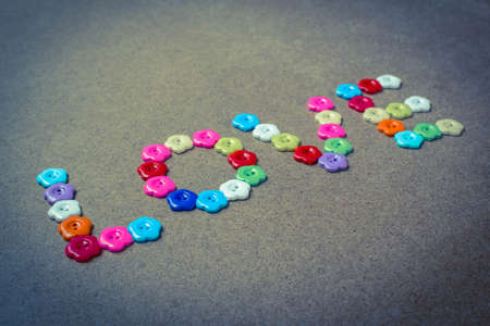 Love written with flower button on wood,Valentines day background.の写真素材