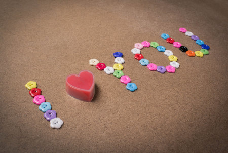I love you written with flower button on wood,Valentines day background.