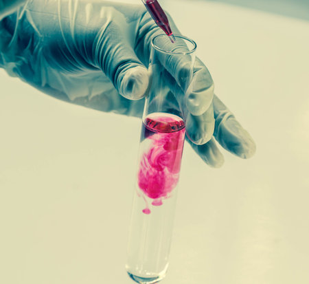 Scientist hand holding a Test tubes close up on blue background,Laboratory research.