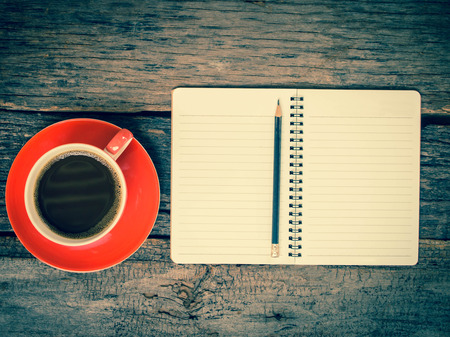 Open a blank white notebook, pencil and cup of coffee on the tableの写真素材