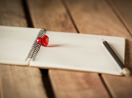 Decorative red heart on the blank page of notebookの写真素材