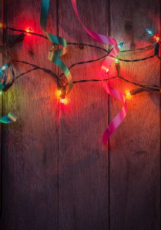 christmas light and ribbon on wood backgroundの写真素材