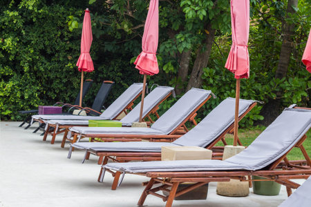 Gray long chairs set by swimming pool