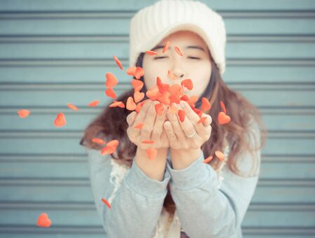 Lovely girl playing with little hearts,valentines day backgroundの写真素材