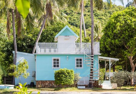 Blue house with porch and white railings with summer landscape.の写真素材