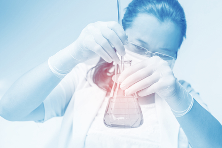 Medical or scientific researcher with flask making test or research in clinical laboratoryの写真素材