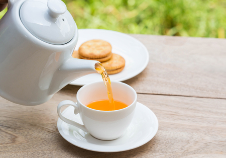 Tea pouring into cup from teapot.の写真素材
