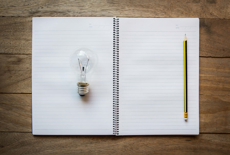 notebook with light bulbs on wood, Creative idea concept.の写真素材