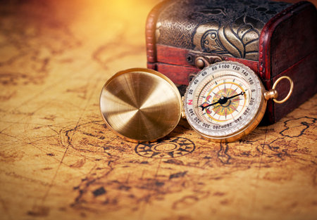 Old compass on vintage map with treasure Chest