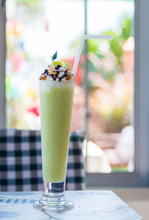 Melon smoothie in glass on a table.の写真素材