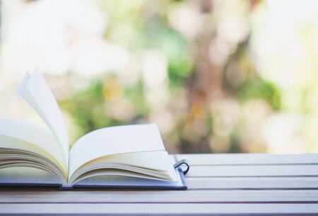 Open book on wooden table with abstract light background.の写真素材