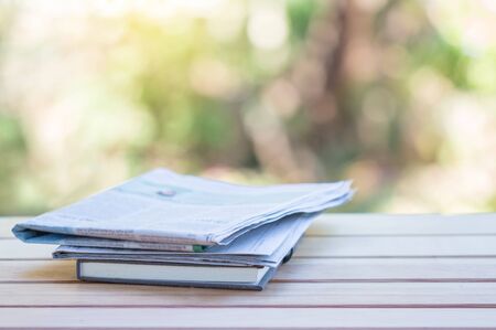 Daily newspaper on the wooden table with nature abstract background.の写真素材