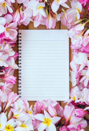 Notebook with flowers on a wooden backgroundの写真素材