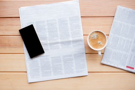 cup of coffee with Newspaper and smartphone in coffee shop.の写真素材