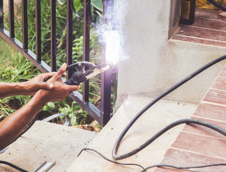 Welder welding steel and sparks metal close door.