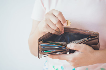 Hands holding Thai baht coin and Empty wallet.