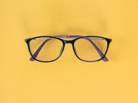 Black glasses on yellow background.