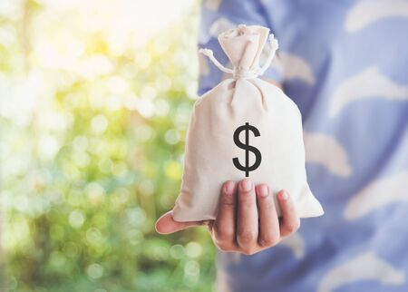 Female hand holding a money bag ,Earning money,Banking, investment, concept.の写真素材
