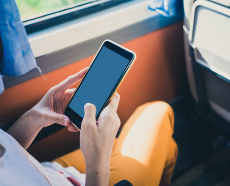 Woman using mobile smartphone on train.