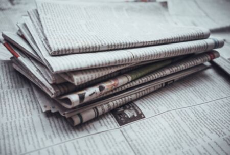 Pile of Daily newspaper on table,blur abstract background.の写真素材