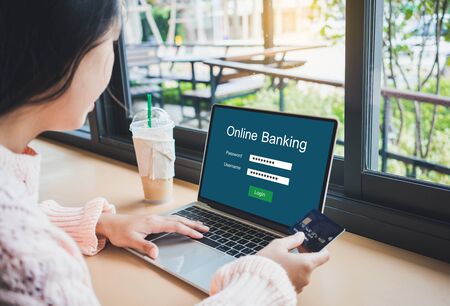 Young woman holding credit card and using online banking on laptop computer.Financial and investment and internet payments shopping network.の写真素材