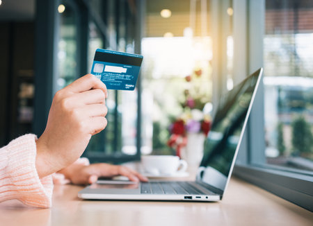 Young woman holding credit card and using online banking on laptop computer.Financial and investment...