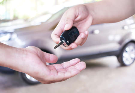 Drive safe. The woman hand gives the car key.の写真素材