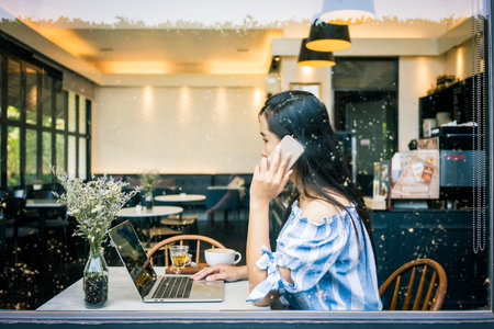 Asian woman using smart phone in the coffee shop.の写真素材